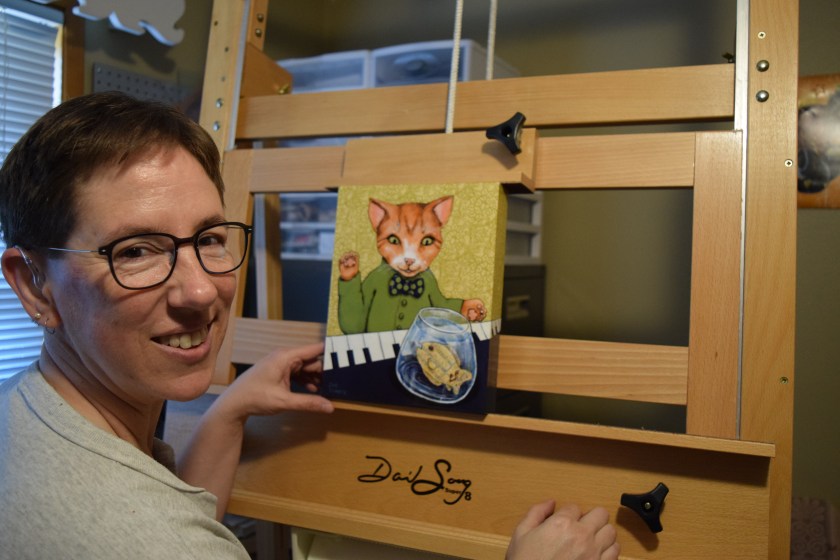 Sue Clancy putting one of her recent artworks on the new easel "to see how it'd work".